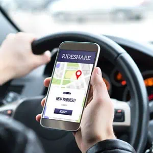 A smartphone displaying a ride share app interface with map and car icons - Mannis Law